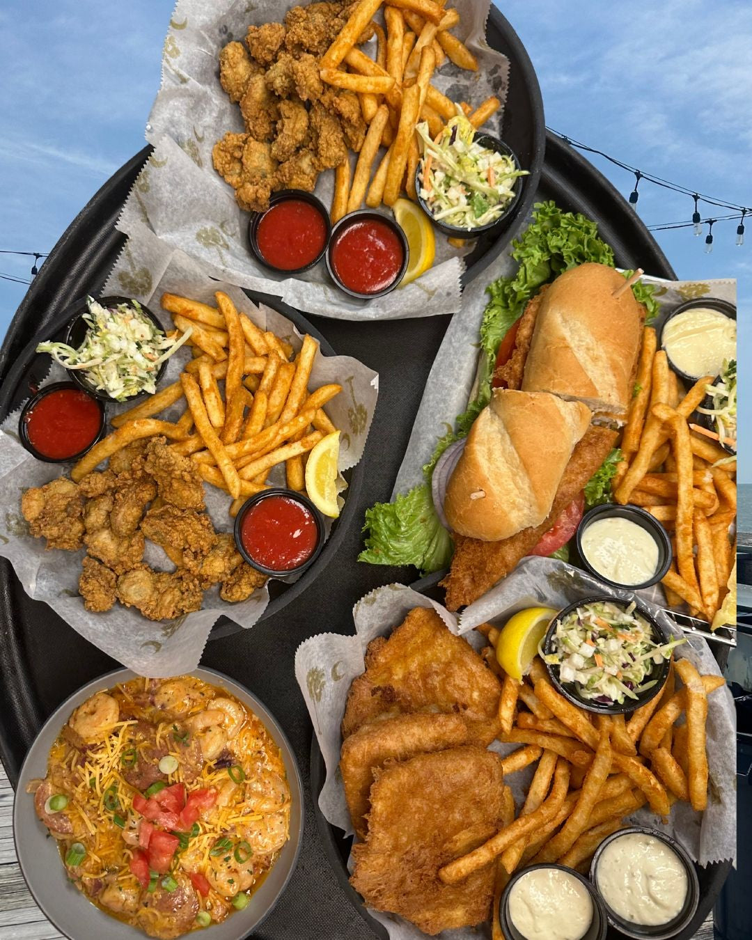 Assorted fried foods including chicken, fish, and fries on a tray with sides.